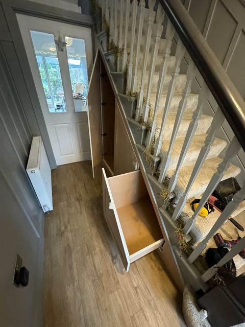 White painted staircase with banister, under-stair drawer and oak flooring