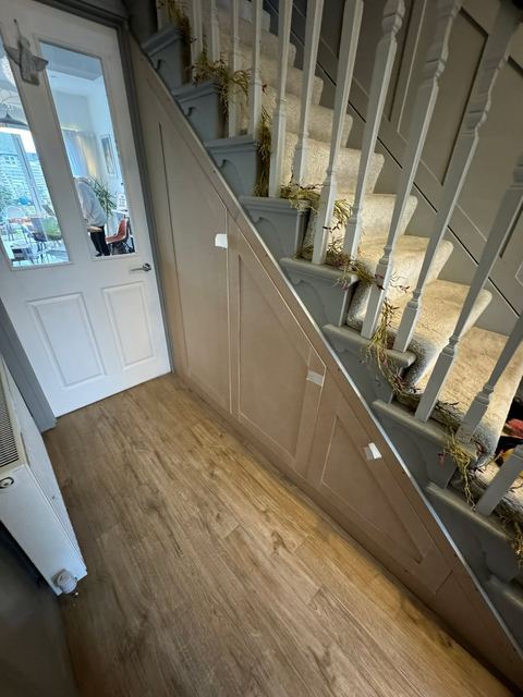 Hallway staircase with white spindles and oak flooring